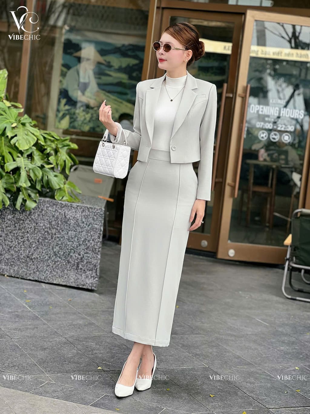 Hình ảnh trình diễn một bộ trang phục công sở thanh lịch và hiện đại, với tông màu xám nhạt chủ đạo tạo nên vẻ ngoài chuyên nghiệp nhưng không kém phầ